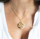 Zoom in of woman in white top wearing large 14k gold porous double layered water reflection necklace by Krista Knickerbocker Designs.