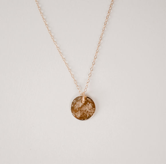 Close up of textured circle gold vermeil pendant hanging from dainty gold filled chain on a white background.  Handcrafted by Krista Knickerbocker Designs.