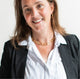 Woman in a white collared shirt and black blazer wearing gold hoop earrings and a handcrafted gold chunky chain necklace by Krista Knickerbocker Designs. 