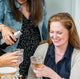 Smiling woman with friends drinking wine and wearing chunky silver handcrafted chain necklace by Krista Knickerbocker Designs.