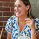 Beautiful woman laughing while wearing handcrafted Krista Knickerbocker Designs rings, dragonfly wing earrings, layered chain necklaces, and cluster bracelet.