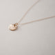 Close up of textured circle gold vermeil pendant hanging from dainty gold filled chain on a white background.  Handcrafted by Krista Knickerbocker Designs.