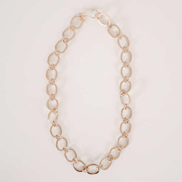 Gold chunky chain necklace with large cast oval links and small round connecting links on a white background.  Item is handmade by Krista Knickerbocker Designs.