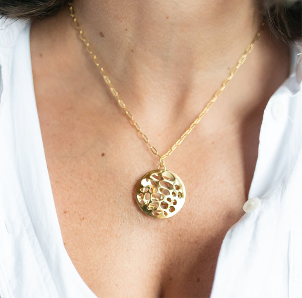 Zoom in of woman in white top wearing large 14k gold porous double layered water reflection necklace by Krista Knickerbocker Designs. 